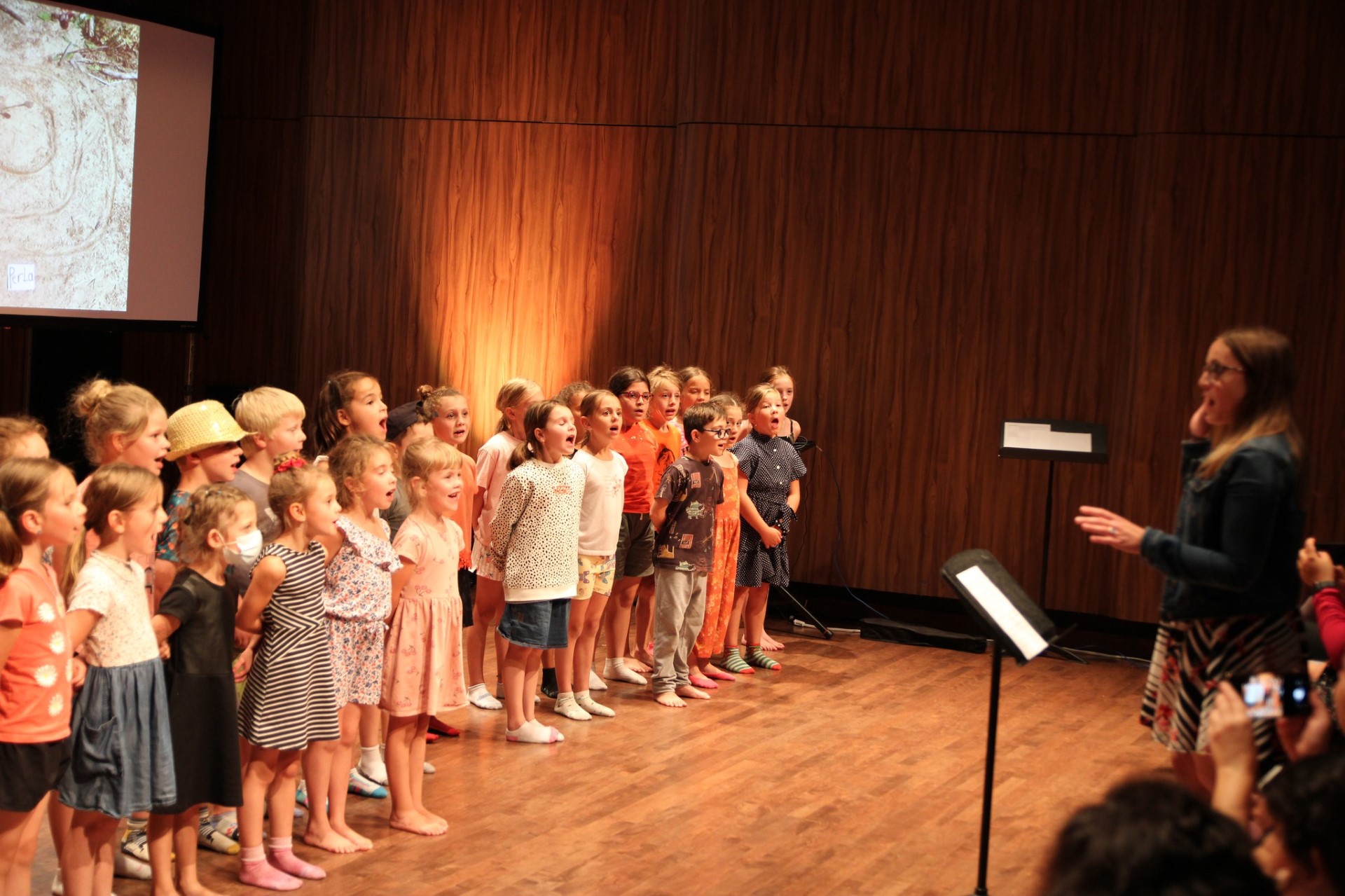 Une chorale de jeunes élèves chante devant un public. Cette chorale est dirigé par le Le Centre de musique et de danse de Val-d’Or. Ces enfants suivent une formation artistique avec le CMDVD.